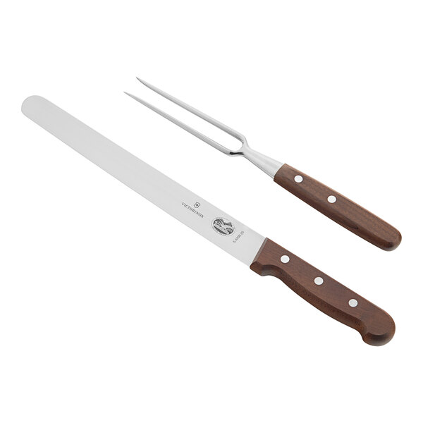 A close-up of a Victorinox meat fork and knife with wooden handles.