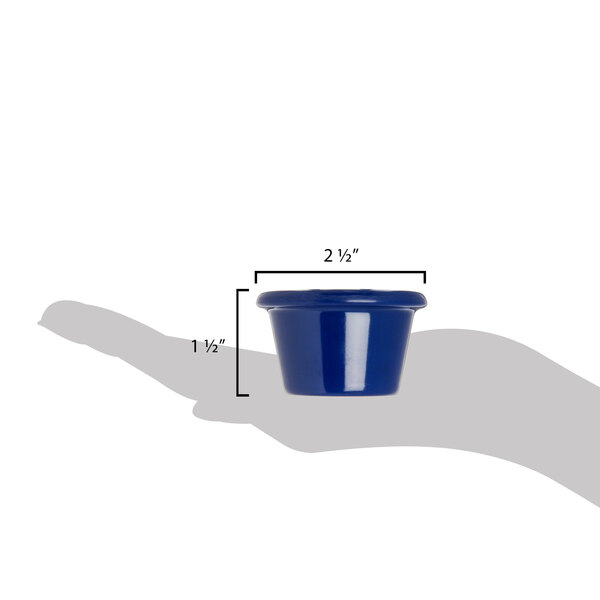 A hand holding a Carlisle cobalt blue melamine ramekin.