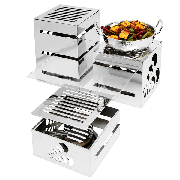 A stainless steel Eastern Tabletop buffet shelf holding metal containers of food on an outdoor table.