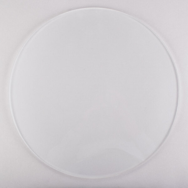 A clear circle on a white surface with a white plate on it.