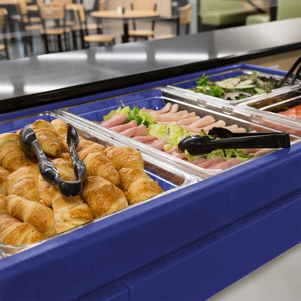 A navy blue Cambro buffet with food on a counter.