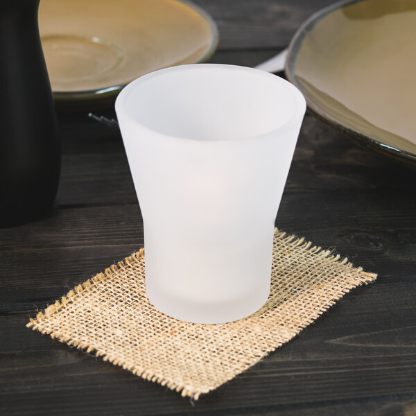 A Sterno fluted glass votive on a burlap napkin.