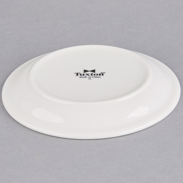 A Tuxton bright white narrow rim china plate with black text that reads "Tuxton"