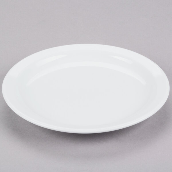 A Tuxton Colorado white plate with a narrow rim on a gray surface.