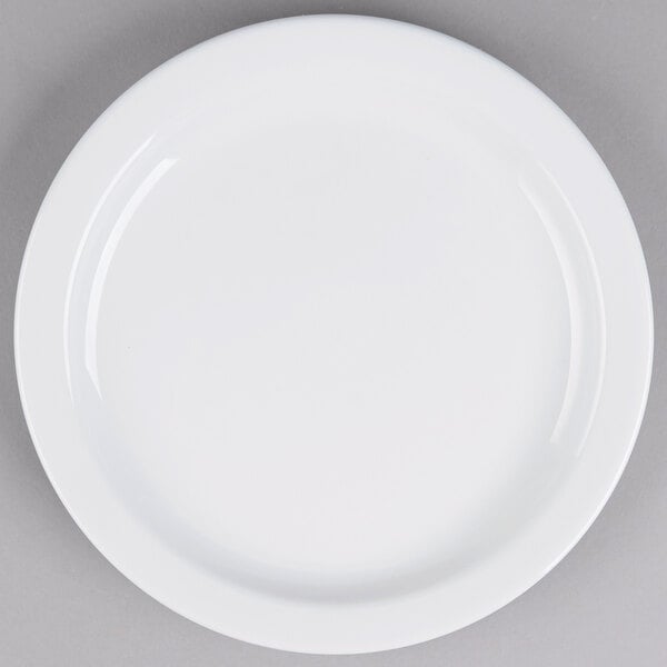 A Tuxton Colorado white china plate with a white rim on a gray surface.