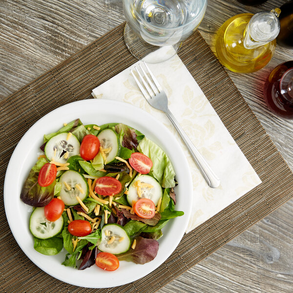 A Tuxton Colorado bright white narrow rim china plate with a salad of tomatoes and cucumbers.