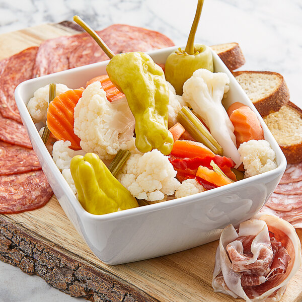 A bowl of Giardiniera with peppers, olives, and salami.