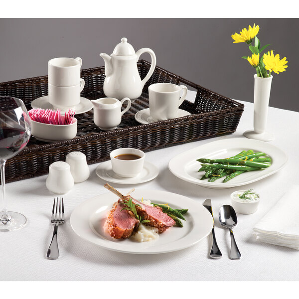 A table set with Homer Laughlin Ameriwhite china platters and white coffee cups.