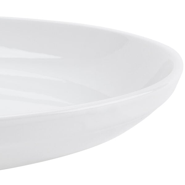 A close up of a CAC Super Bright White porcelain salad bowl with rolled edges.