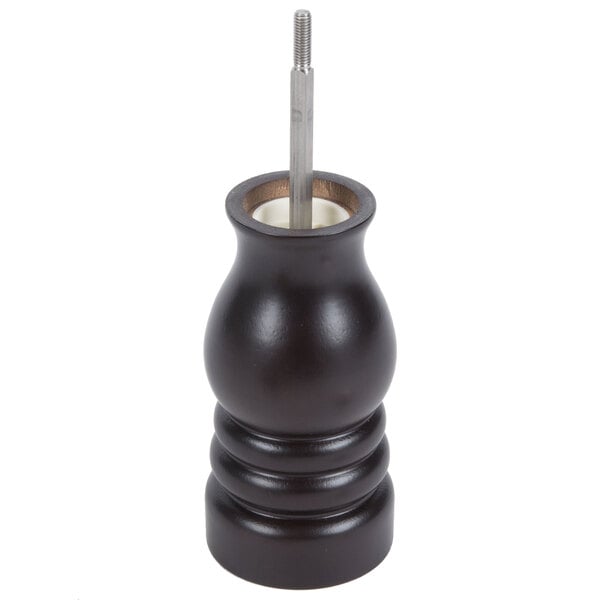A black wooden Chef Specialties pepper mill with a metal handle and knob on a counter.