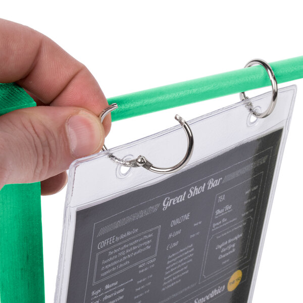 A hand holding a teal wood flip top table tent menu card.