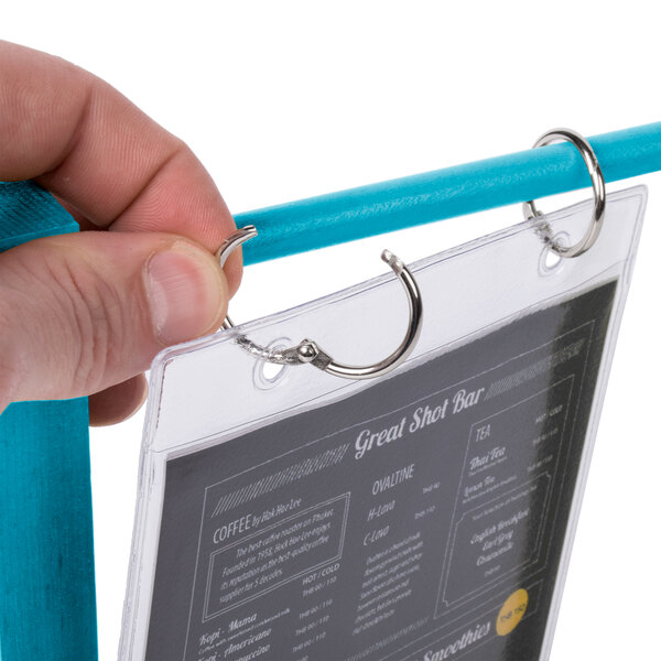 A hand holding a Menu Solutions Sky Blue Wood Flip Top Table Tent.