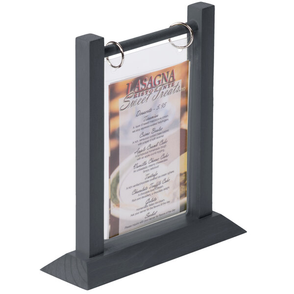 A Menu Solutions ash wood flip top table tent holding a menu on a table.