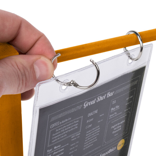 A hand holding a Menu Solutions oak wood table tent.