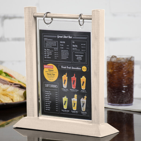 A Menu Solutions wood table tent on a table with a sandwich and a drink.