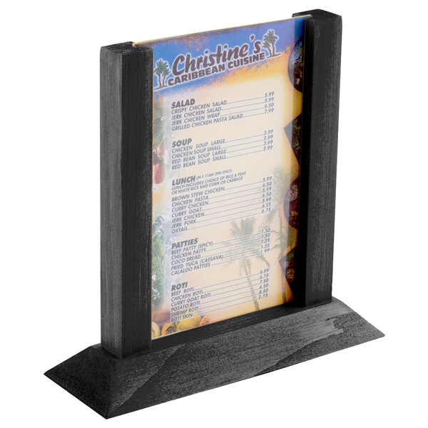 A black wood Menu Solutions table tent with a menu on it.