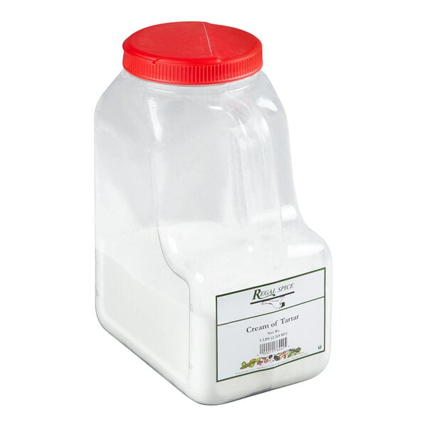 A clear plastic container with a red lid full of Regal Cream of Tartar.