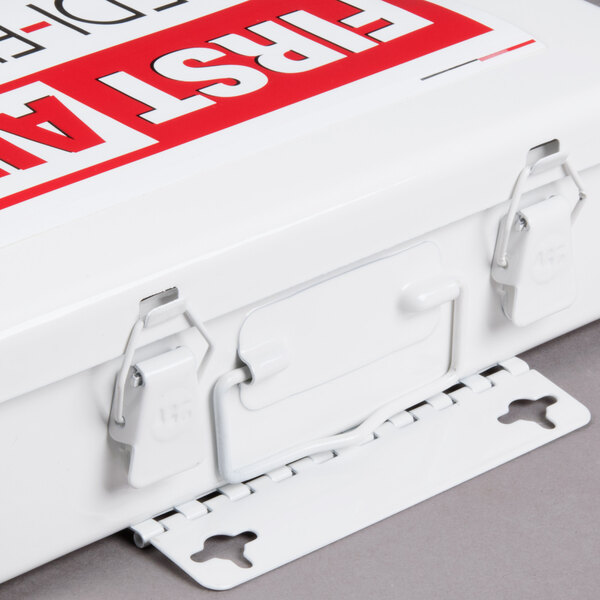 A white metal Medique first aid kit box with red and white text.