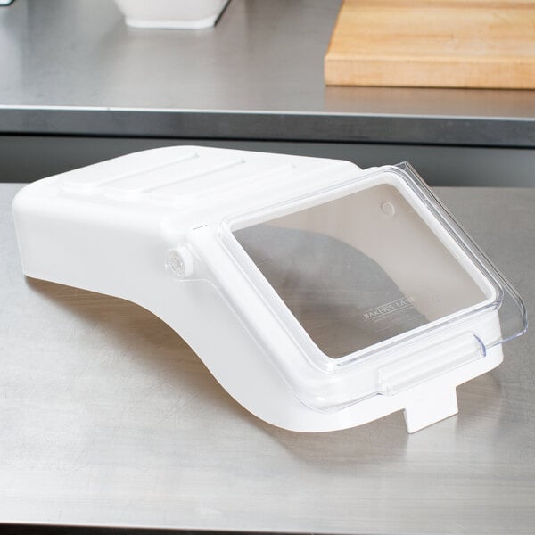 A clear plastic lid on a white Baker's Lane ingredient bin.