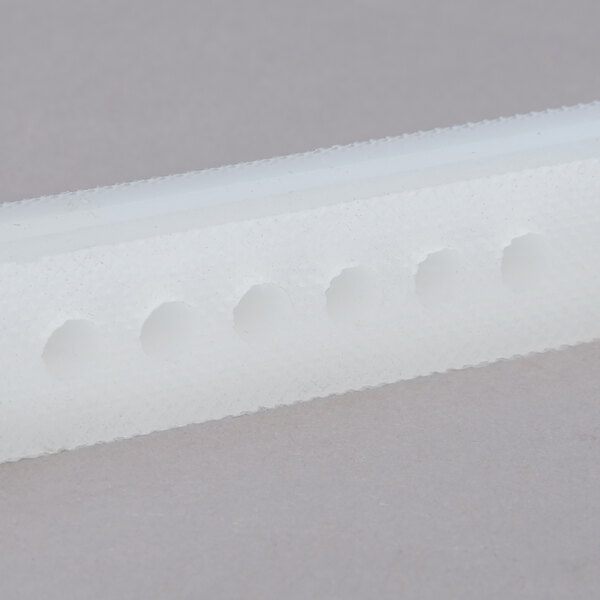 A white plastic object with holes.