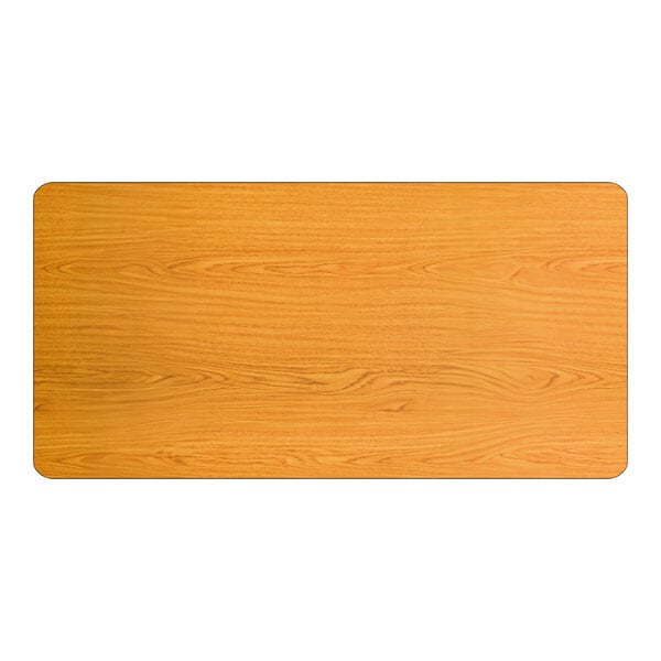 A rectangular laminated table top with a light oak wood finish and rounded corners.