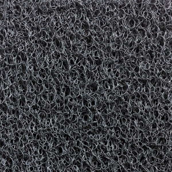 A close-up of a grey unbacked scraper mat with a pile of black wire coils.