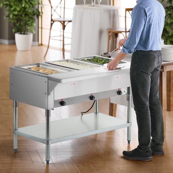 A three-pan electric hot food table with an undershelf and sealed wells, designed for keeping food warm in a buffet or catering setting.