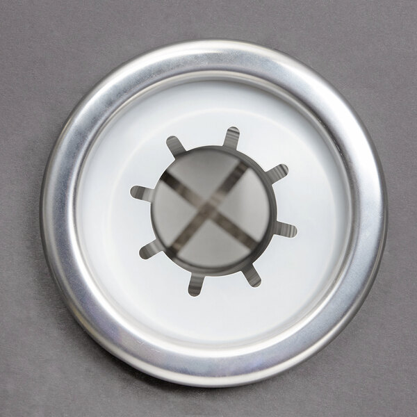 A circular silver object with a cross in the center.