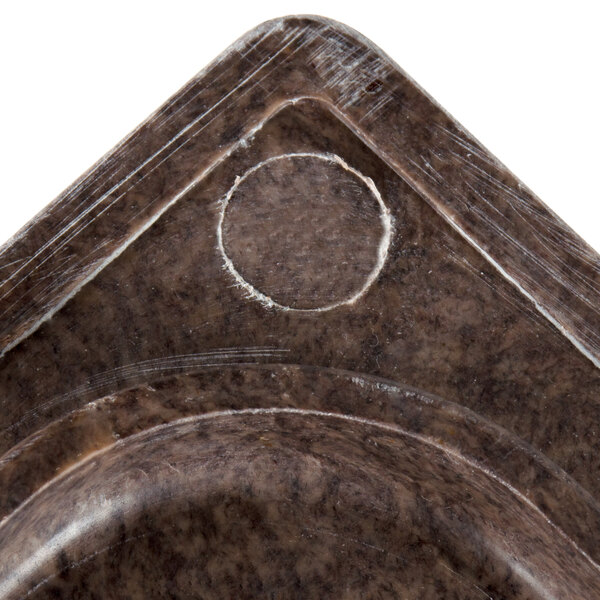 A brown granite resin template with a circle cut out of it.