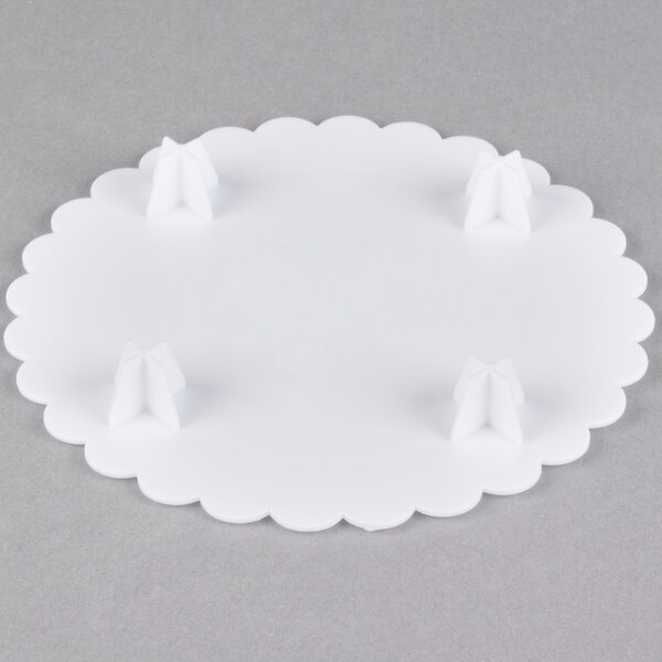 A white Wilton scalloped edge cake separator plate.