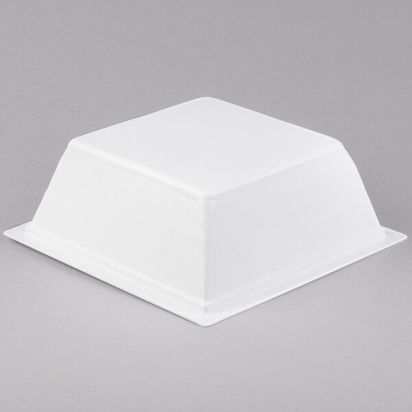 A white square porcelain bowl with liner in a white square dish on a gray surface.