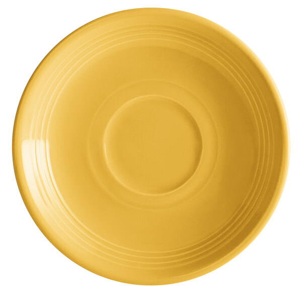 A close-up of a Tuxton saffron saucer with a circular pattern on it.