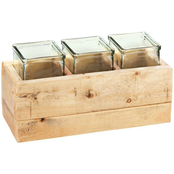 A wooden box with three glass jars inside.