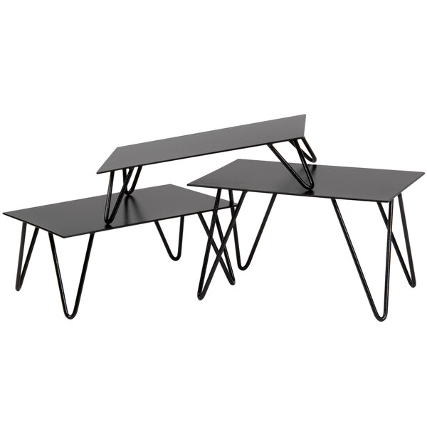 A stack of black metal rectangular display risers with metal legs.