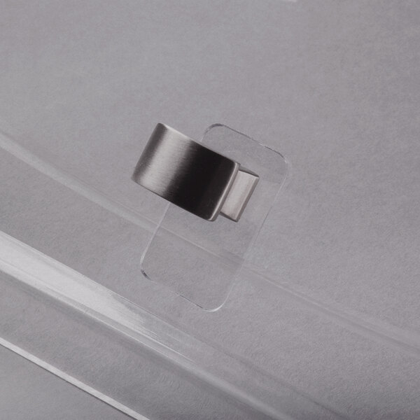 A close-up of a metal ring with a silver metal clip on a clear plastic box.