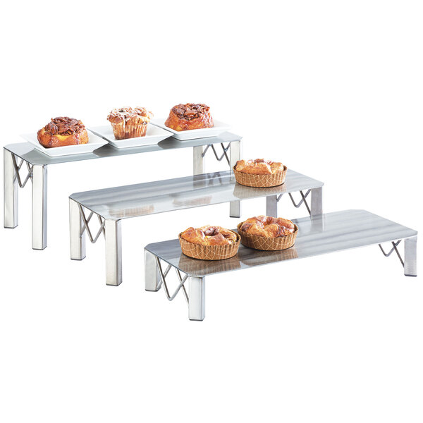 A Cal-Mil Industrial rectangle riser holding trays of pastries on a table.