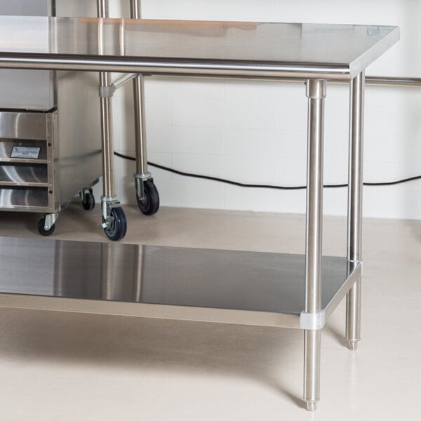 An Advance Tabco stainless steel work table with undershelf and wheels.