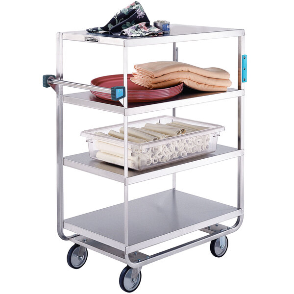 A Lakeside stainless steel utility cart with three shelves of towels and food on a tray.