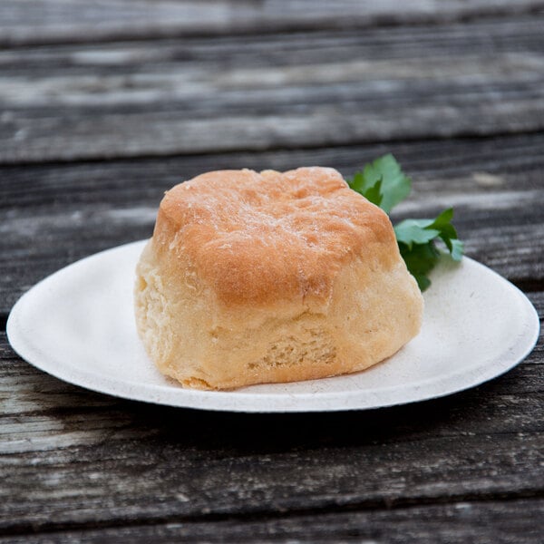 A biscuit on a Green Wave Ovation sugarcane plate with a green leaf.