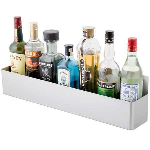 A stainless steel speed rail with bottles of liquor on it.