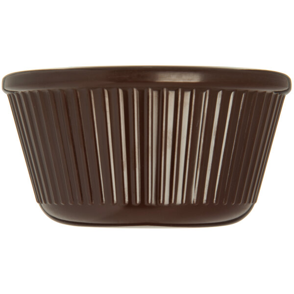 A brown fluted ramekin with a white background.