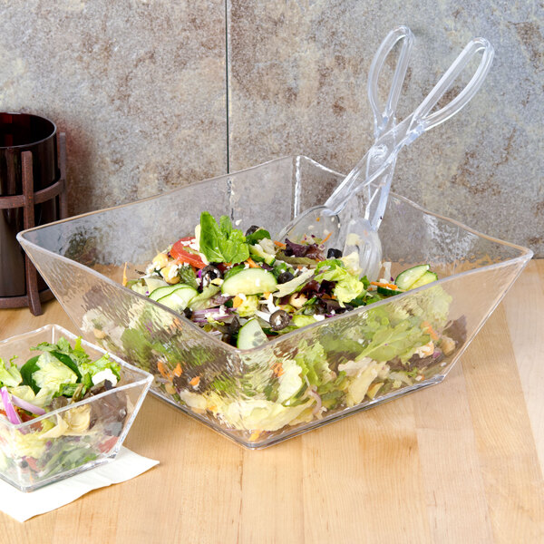A salad in a clear square bowl.