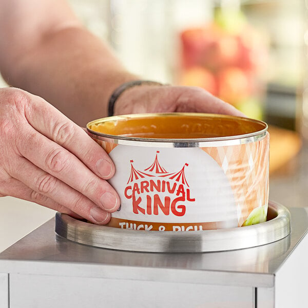 two hands placing a can of caramel dip into soup warmer
