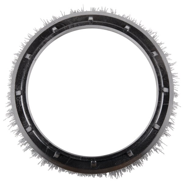 A circular gray Oreck grit scrub brush with metal spikes.