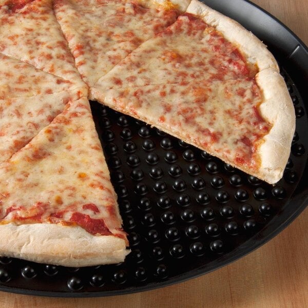 A cheese pizza with a slice missing on a black HS Inc. pizza tray.