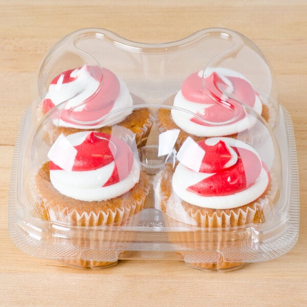 4-compartment clear container containing 4 red and white frosted cupcakes