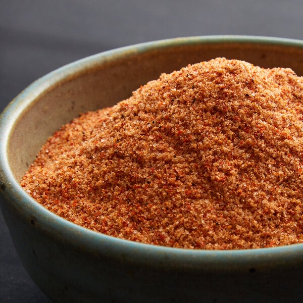 A bowl of brown powder with red and black specks.