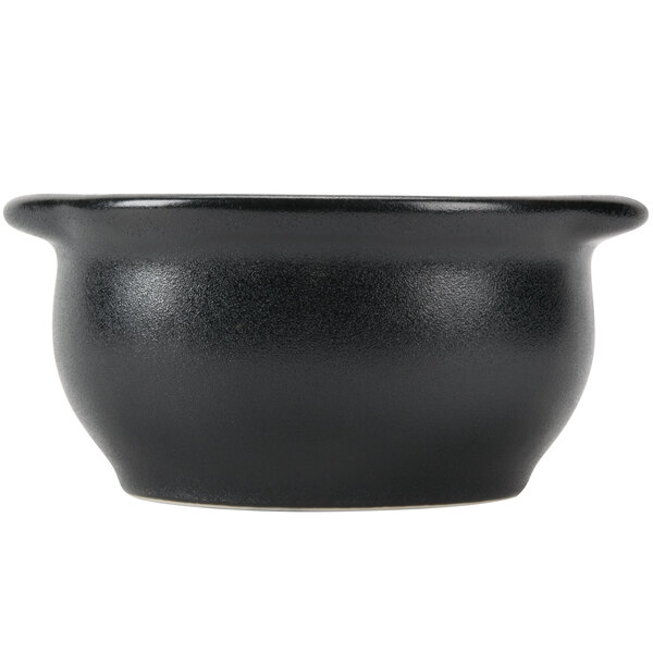 A close-up of a black Hall China onion soup bowl with a handle.