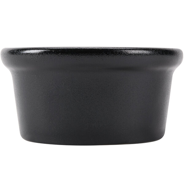 A close-up of a black Hall China round ramekin.