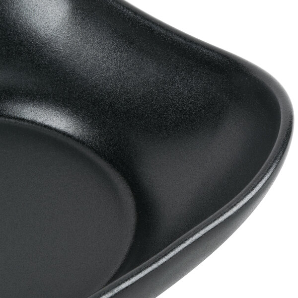 A black square bowl with scalloped edges.
